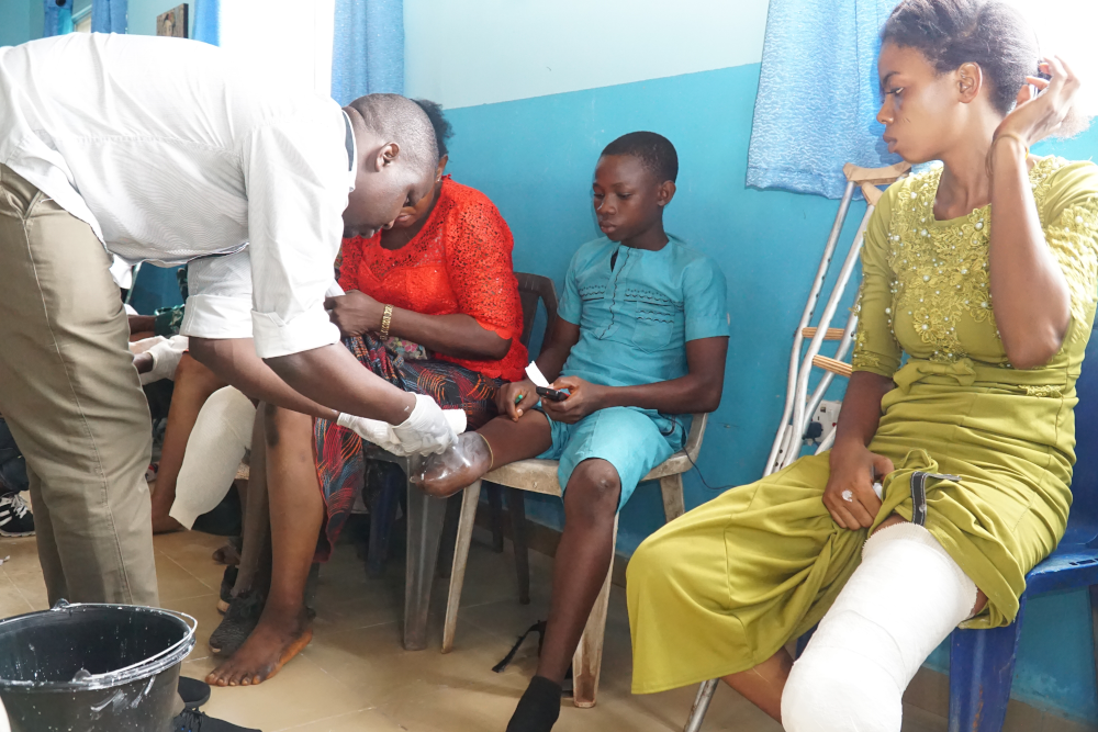 Orthopaedic technician measures a boy for a prosthesis